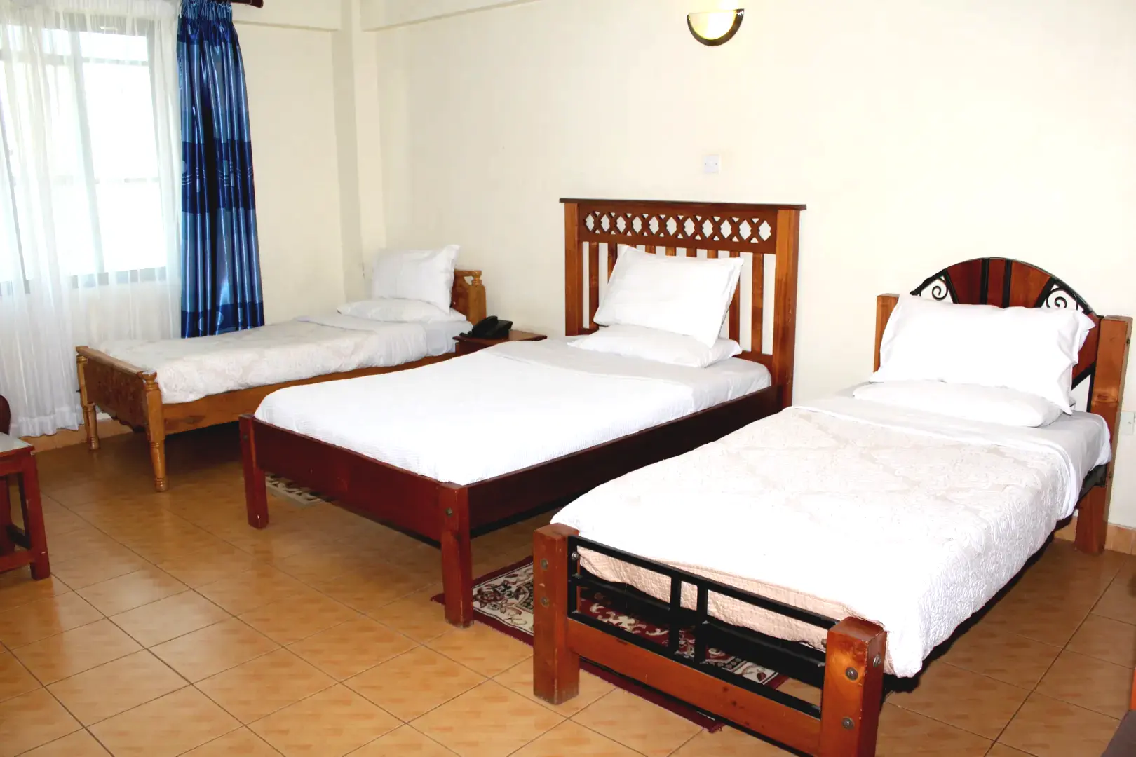 Meru Paramount Hotel Triple Bedroom features three cozy single beds with soft linens to ensure everyone enjoys a good night’s sleep.